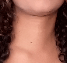 a close up of a woman 's neck showing a small hole in it