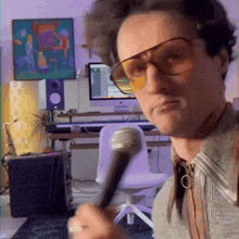 a man wearing sunglasses is holding a microphone and making a funny face
