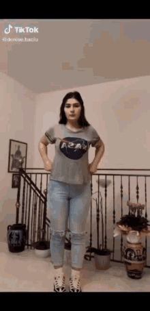 a woman wearing a nasa t-shirt is standing in front of a staircase