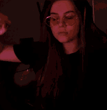 a woman wearing a pair of pink glasses with a reflection of her face
