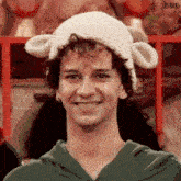a man wearing a knitted hat with sheep ears smiles