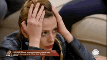 a woman with her hands on her head is on a television screen with a caption that starts with the word record