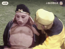 a man in a pig mask is being held by another man in a yellow hat