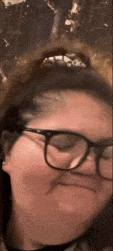 a woman wearing glasses is making a face
