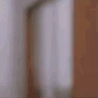 a blurry picture of a person peeking out from behind a wall .