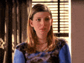 a woman wearing a blue tie dye shirt and a necklace