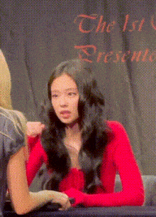 a woman in a red shirt is sitting at a table with another woman and the words " the 1st present " on the bottom