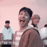 a man is laughing with his mouth open in front of a pink wall
