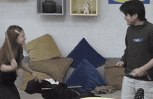 a man and a woman are playing a game on a couch with pillows