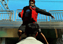 a man wearing a red jacket with the number 10 on it is jumping in the air