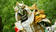 a person in a white and gold costume is standing in front of a forest .