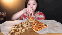 a woman is dipping a slice of pizza in sauce