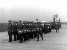 a black and white photo of soldiers marching on a road