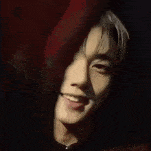 a close up of a person 's face with a red background .