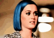 a woman with blue hair is making a face .