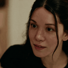 a close up of a woman 's face with a black shirt