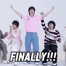 a man in a pink shirt stands in front of a sign that says finally !!!