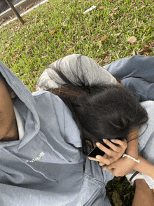 a woman laying on a man 's lap with a blue hoodie that says ' abercrombie ' on it