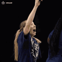 a woman wearing a blue shirt that says ' ncaaw ' on it