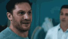 a man with a beard is standing next to a doctor and making a funny face .