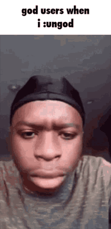 a man wearing a hat and a t-shirt is making a sad face .