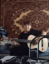 a person playing a guitar in front of a rug that says minimax on it