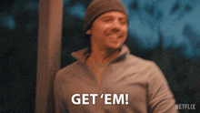 a man wearing a beanie says get 'em