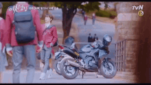 a motorcycle is parked on the side of the road with a tvn logo in the background