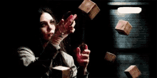 a woman is holding a red object in her hands in a dark room with a red light coming out of her hands .