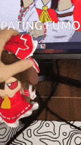 a person is petting a stuffed animal in front of a tv screen that says pating fumo