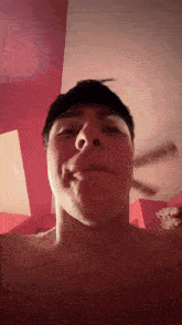 a man without a shirt is making a funny face in front of a fan