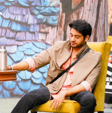 a man is sitting in a chair with a coca cola bottle in the background