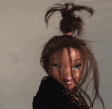 a doll with messy hair is wearing a black shirt .