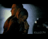 a man and a woman are standing next to each other on a street with the words ello.tv on the bottom right