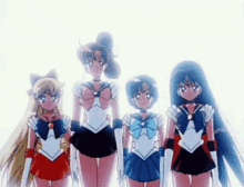 a group of sailor moon characters are standing next to each other in a line .