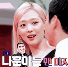 a woman with pink hair is looking at a man with a microphone in front of her and the words " jellyday329 " are above her