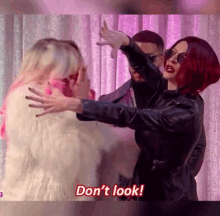 a woman with red hair is standing next to a man in a fur coat .