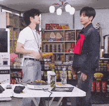 two men are standing in front of a machine that says r & mane