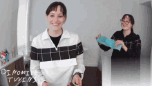 a woman holding a remote control with the words dynamite twins below her