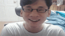 a man wearing glasses and a white shirt is smiling