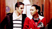a man and a woman are standing next to each other and the woman is wearing a jacket that says tm on it
