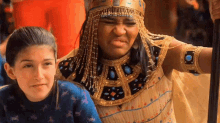 a woman in a costume is standing next to a girl in a blue shirt .