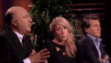 a man in a suit is talking to a woman and a man in a suit is listening