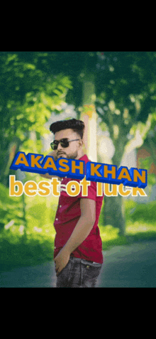 a man wearing sunglasses stands in front of a sign that says akash khan