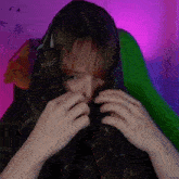 a person is covering their face with a plaid blanket