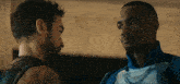 two men are standing next to each other and talking to each other