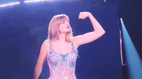 gif of taylor performing in the lover bodysuit, flexing and kissing her bicep