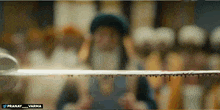 a man with a beard is holding a sword in front of a sign that says pranay_varma