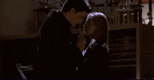 a man and a woman are looking at each other in the dark