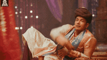a man in a turban sits on a chair